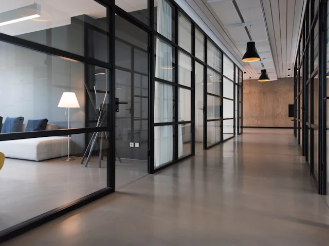Open-plan office with carpet tile flooring, desks and meeting rooms